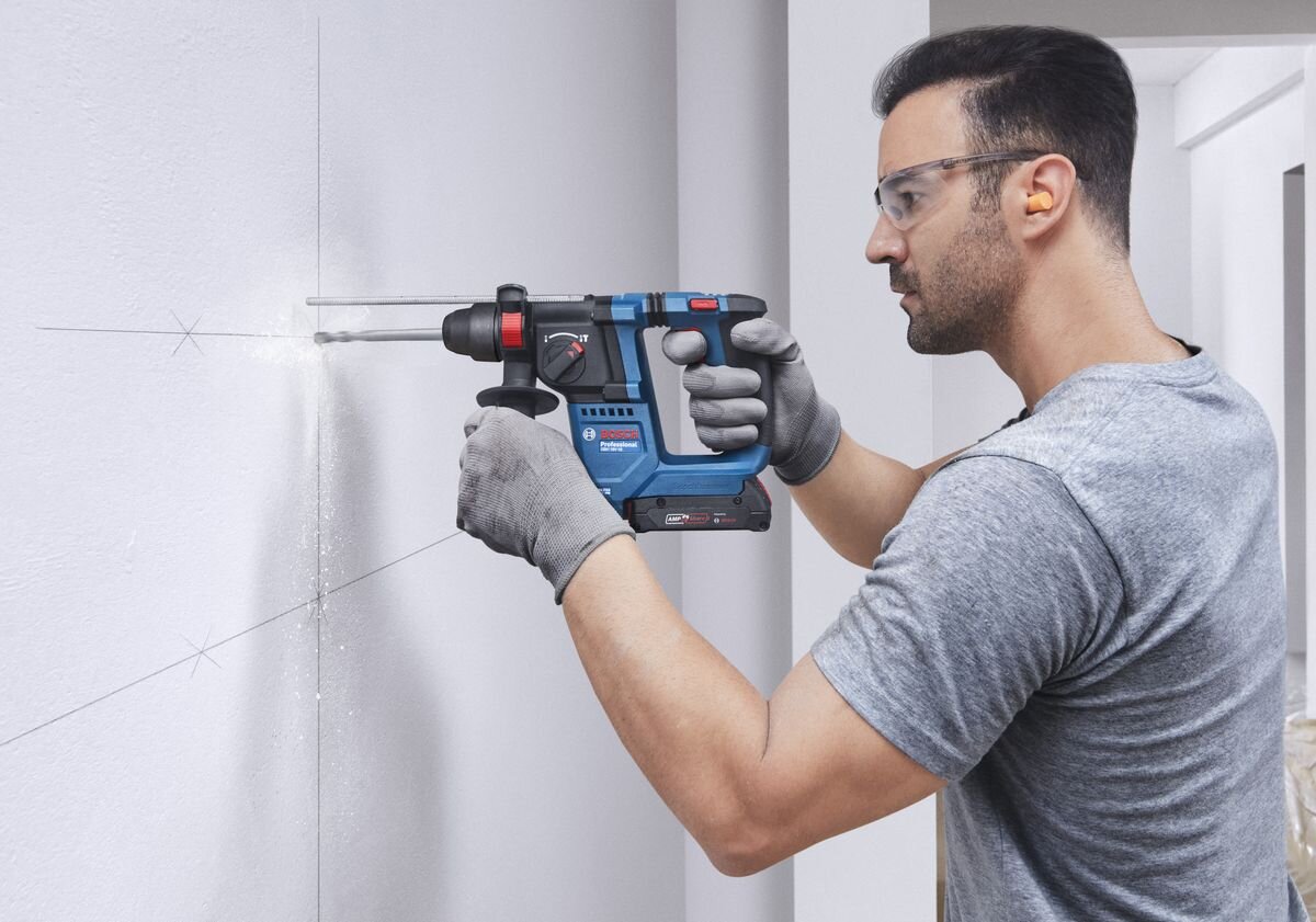 BOSCH Professional GBH 18V-18 0611927001 - Mężczyzna używa akumulatorowego młota udarowo-obrotowego do pracy z drewnianym elementem.