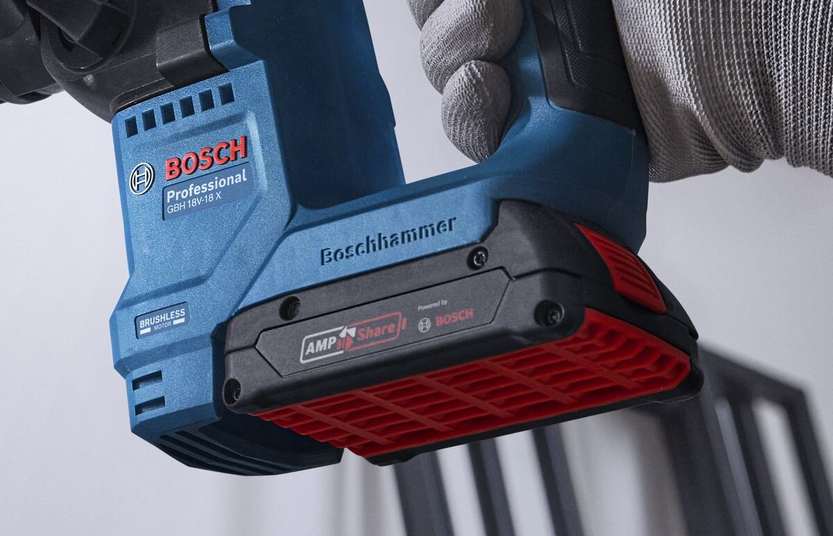 BOSCH Professional GBH 18V-18 0611927002 akumulator systemem BOSCH GBA 18 V i ProCore 18 V młotami o niższym napięciu - Zbliżenie na dłonie mężczyzny obsługującego akumulatorowy młot udarowo-obrotowy podczas pracy w drewnie.