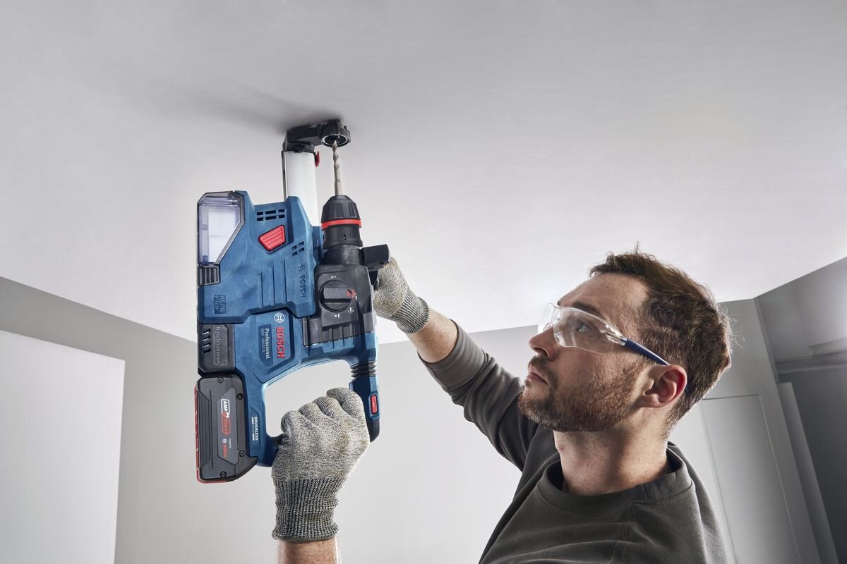 BOSCH GBH 18V-22 X BOSCH GBH 18V-22 X system Vibration Control młotami bez tłumienia drgań - Mężczyzna wierci otwór w suficie przy pomocy urządzenia