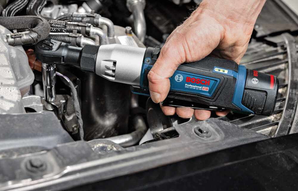 Klucz akumulatorowy grzechotka BOSCH Professional GRC 12V-60 3-8 SN 06019N8301 warsztat silnik osoba dokręca śrubę w silniku mały obwód rękojeści przemyślany kształt obudowy o wymiarach 52 x 73 x 269 mm poprawiają kontrolę nad narzędziem antypoślizgowa powierzchnia stabilizuje chwyt