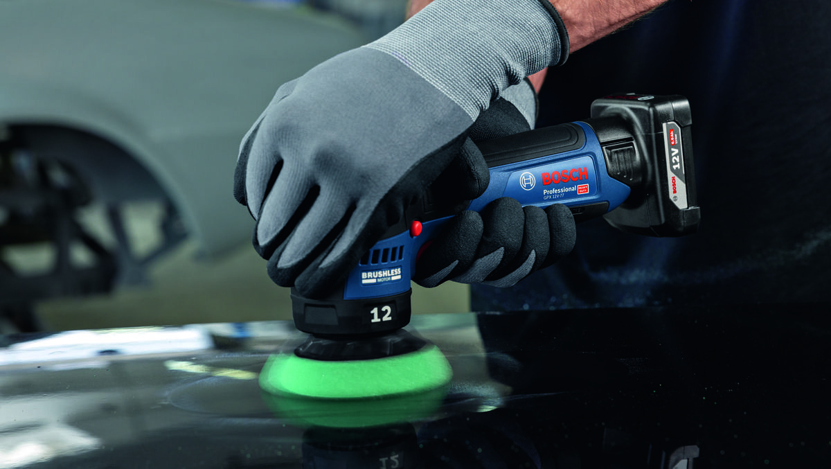 Osoba w rękawicach trzyma polerkę z logo BOSCH Professional, używając jej na ciemnej powierzchni. Na urządzeniu widoczny jest napis \'BRUSHLESS\' oraz liczba \'12\'.