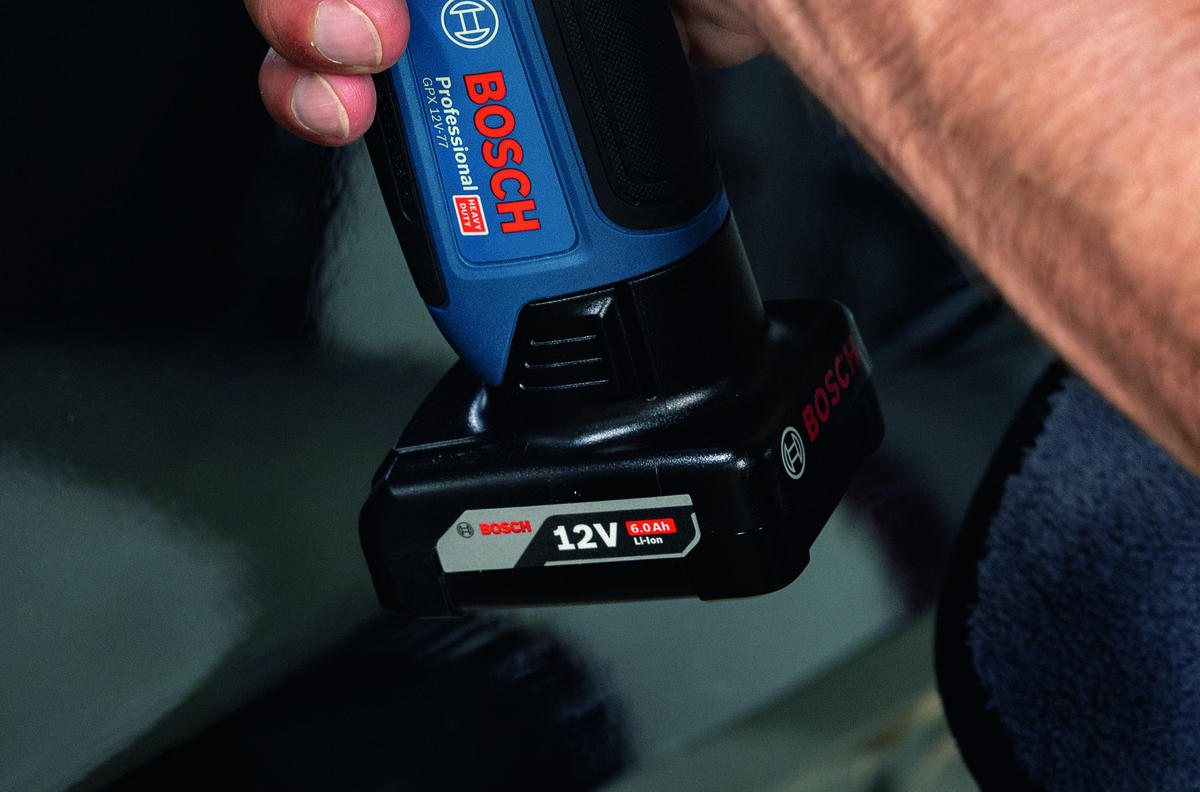 Osoba trzyma niebieską polerkę z logo BOSCH Professional, na której widoczny jest napis \'12V 6.0Ah Li-Ion\'.