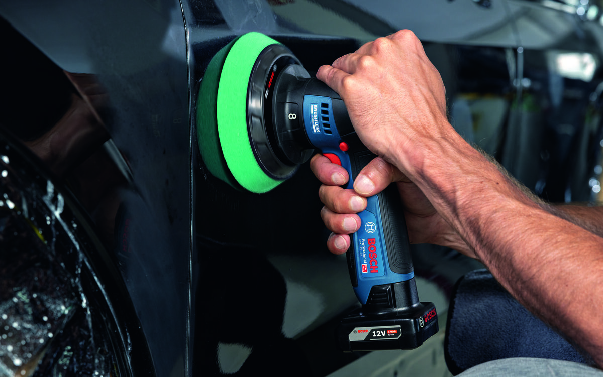 BOSCH Professional GPX 12V- 125 06019L4100 - Mężczyzna poleruje czarną karoserię samochodu przy użyciu polerki akumulatorowej Bosch.