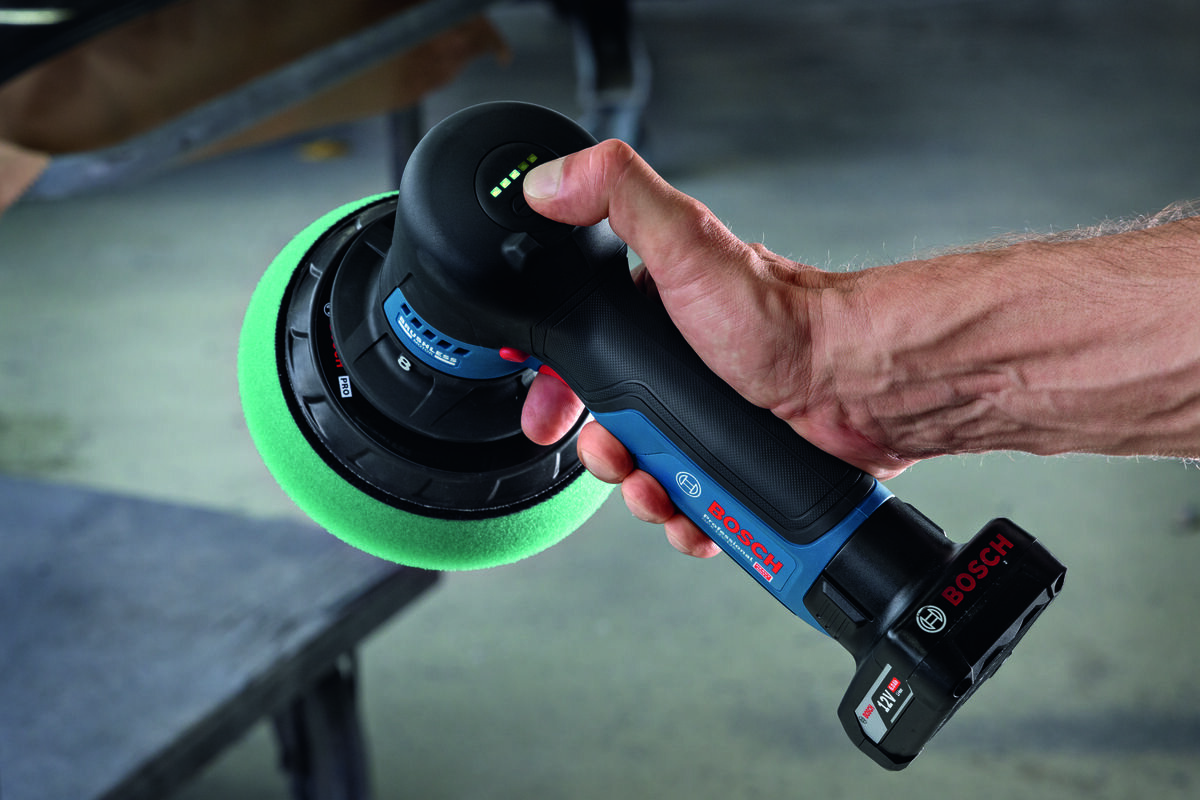BOSCH Professional GPX 12V- 125 06019L4100 Interfejs HMI poziom naładowania akumulatora umożliwia wybór jednego z 5 ustawień prędkości stan zasilania dopasować parametry - Mężczyzna trzyma polerkę akumulatorową Bosch i sprawdza stan naładowania baterii przyciskiem na obudowie.