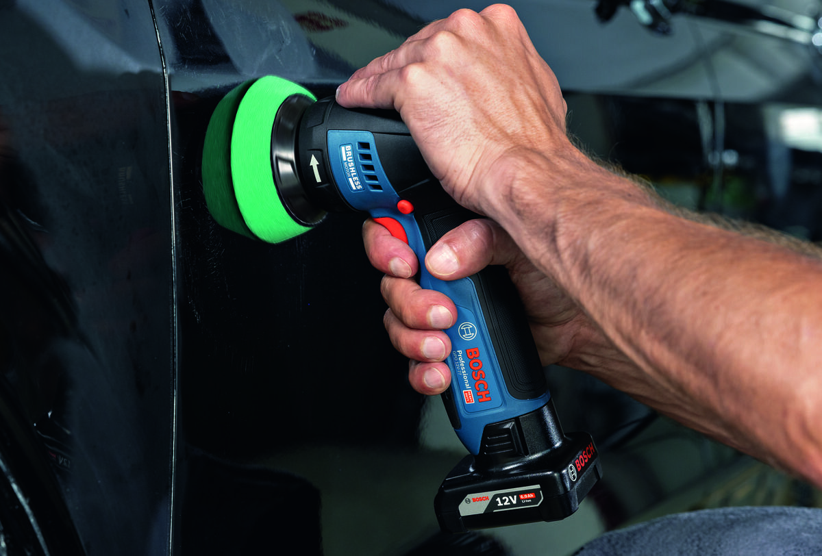BOSCH Professional GPO 12V-77 06019L3000 - Mężczyzna poleruje czarną karoserię samochodu przy użyciu polerki akumulatorowej Bosch.