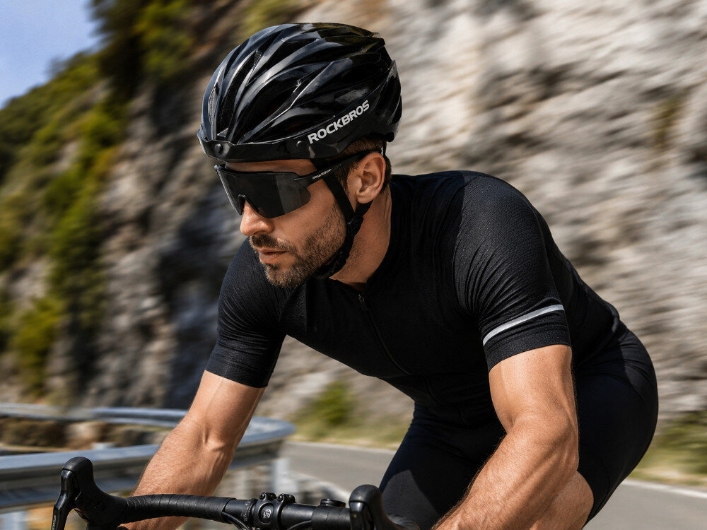 Kask rowerowy ROCKBROS 8386824304077 Czarno-brązowy Szosowy (rozmiar 58-62), kask, rower, bezpieczeństwo, styl, Kolarz w czarnym stroju jadący po górskiej drodze.