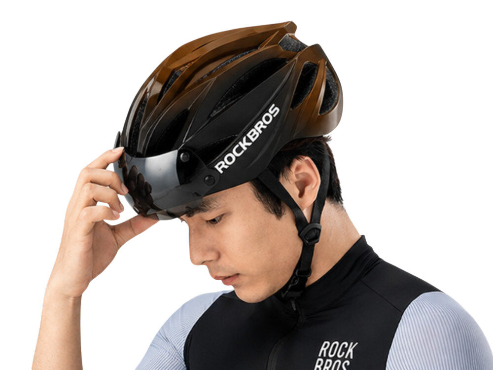 Kask rowerowy ROCKBROS 8386824304077 Czarno-brązowy Szosowy (rozmiar 58-62), regulacja, dopasowanie, ce, ochrona, Mężczyzna dłonią ustawia wizjer w kasku rowerowym.