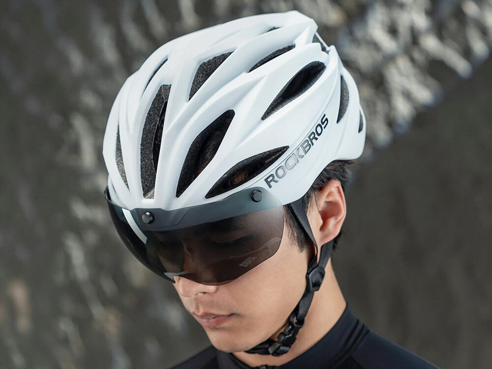 Kask rowerowy ROCKBROS 8386824304060 Biały Szosowy (rozmiar 58-62), kask, rower, bezpieczeństwo, styl, Mężczyzna w białym kasku z wizjerem patrzy w dół.