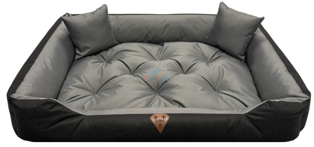 Legowisko dla psa OSKAR Comfortable pies i opiekun razem w salonie elegancki wygląd produktu szaro-czarne, prostokątne legowisko dla psa Oskar z wysokimi, pikowanymi bokami i dwoma małymi poduszkami w narożnikach. Na froncie widoczna brązowa, skórzana naszywka z logo psiej głowy