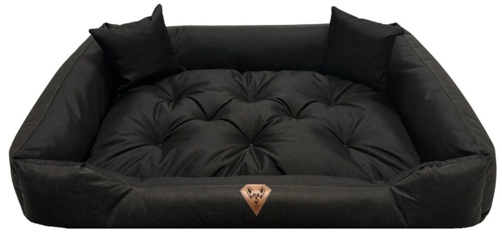 Legowisko dla psa OSKAR Comfortable pies i opiekun razem w salonie elegancki wygląd produktu Czarne, prostokątne legowisko dla psa Oskar z wysokimi, pikowanymi bokami i dwoma małymi poduszkami w narożnikach. Na froncie widoczna brązowa, skórzana naszywka z logo psiej głowy