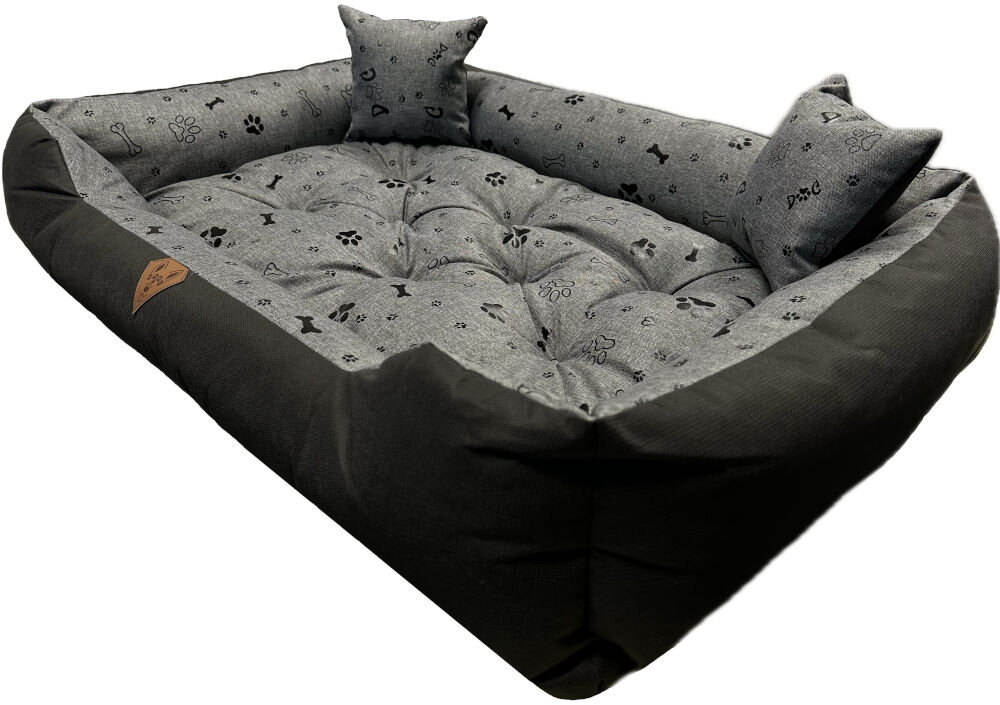 Legowisko dla psa OSKAR Premium o wymiarach 75x65 cm, widziane z góry. Zewnętrzna część jest gładka, czarna, a wnętrze i dwie małe, prostokątne poduszki mają szary wzór w białe i srebrne łapki oraz kości. Na froncie widoczna brązowa, skórzana naszywka z logo