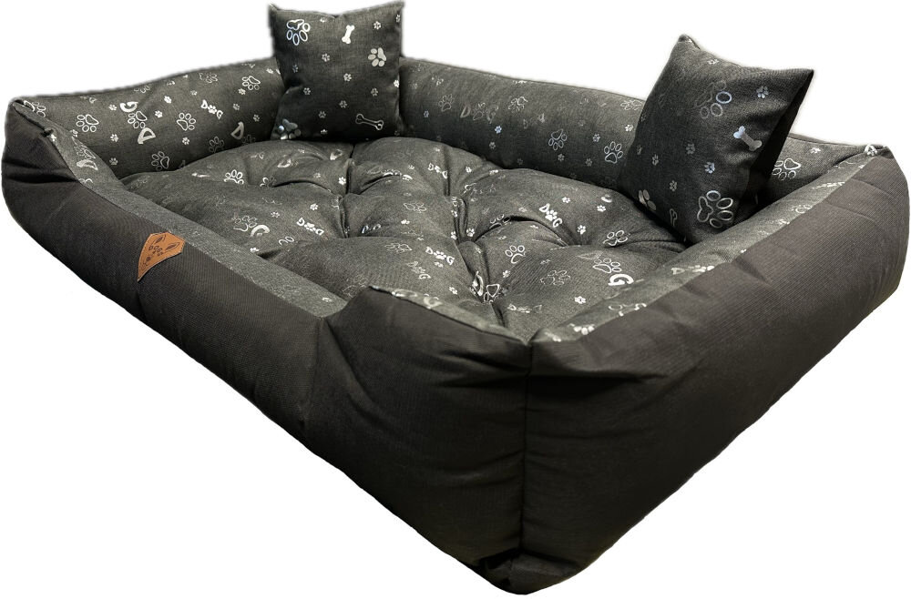 Legowisko dla psa OSKAR Premium o wymiarach 75x65 cm, widziane z góry. Zewnętrzna część jest gładka, czarna, a wnętrze i dwie małe, prostokątne poduszki mają szary wzór w białe i srebrne łapki oraz kości. Na froncie widoczna brązowa, skórzana naszywka z logo