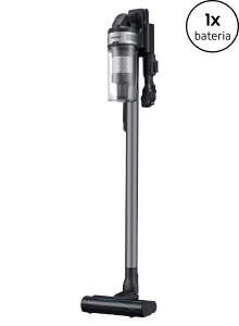 Odkurzacz pionowy w kolorze szarym z przezroczystym pojemnikiem na kurz. W prawym górnym rogu widoczny jest napis \'1x bateria\'.