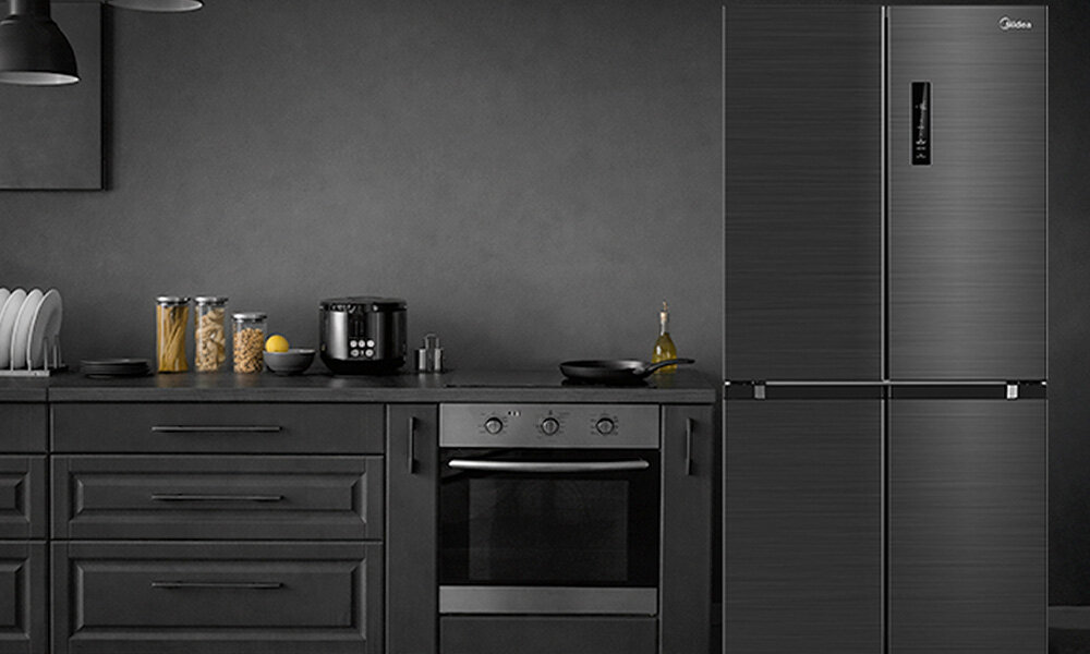 LODÓWKA MIDEA MDRF632FIE45 Kuchnia utrzymana w ciemnej tonacji prezentuje lodówkę o grafitowym wykończeniu dopasowaną do spójnej zabudowy meblowej. Na blacie stoją naczynia i akcesoria, tworząc uporządkowaną i elegancką przestrzeń konstrukcja 4D Czterodrzwiowa kontrola organizacja strefy przechowywanie wygoda porządek sekcje produkty świeże zapasy mrożonki funkcjonalność styl gotowania kuchnia