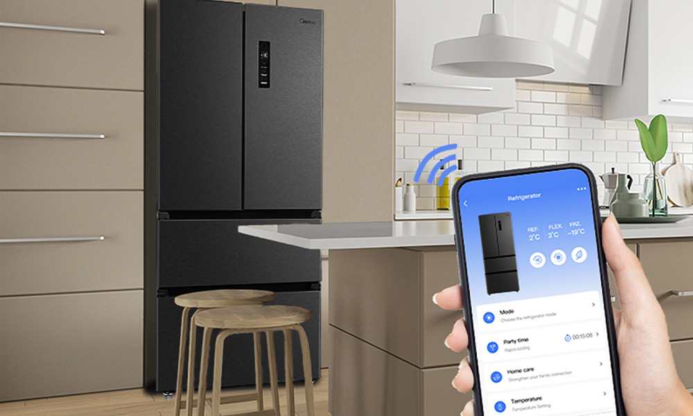 W kuchni znajduje się antracytowa lodówka z dwoma drzwiami i panelem sterowania. Osoba trzyma smartfon z aplikacją do zarządzania lodówką, na ekranie widoczne są opcje: Mode, Party time, Volume care, Temperature.