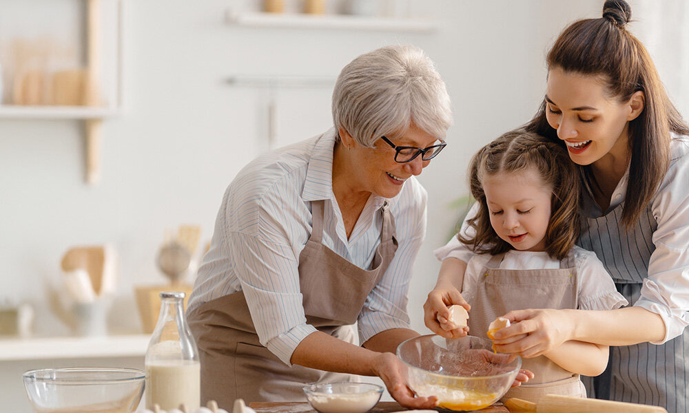 LODÓWKA MIDEA MDRB600MIC45P Trzy osoby wspólnie przygotowują posiłek, dodając składniki do miski. Scena oddaje domową atmosferę i radość ze wspólnego gotowania przestrzeń technologia wolnostojąca pojemność funkcjonalność ciemne wykończenie elegancka