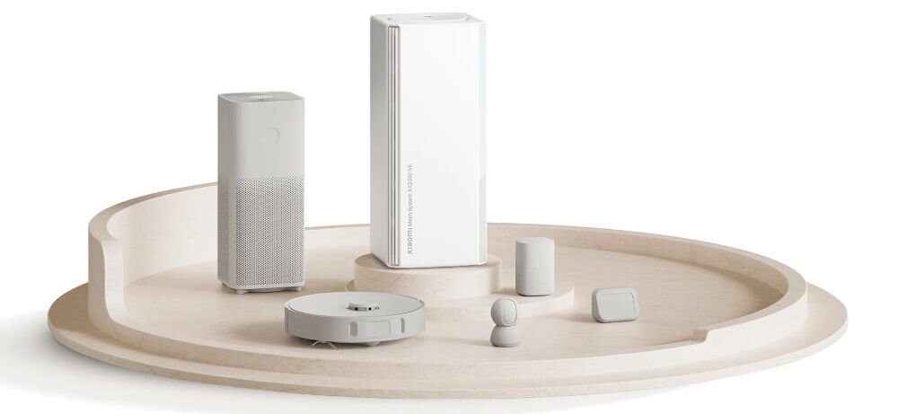 Router XIAOMI Mesh System AX3000 NE 2.4 / 5 GHz (DualBand), Wi-Fi Mesh (1 szt.) prezentacja routera z różnymi urządzeniami obok na beżowej tacy białe tło obsługa do 250 urządzeń stabilna łączność