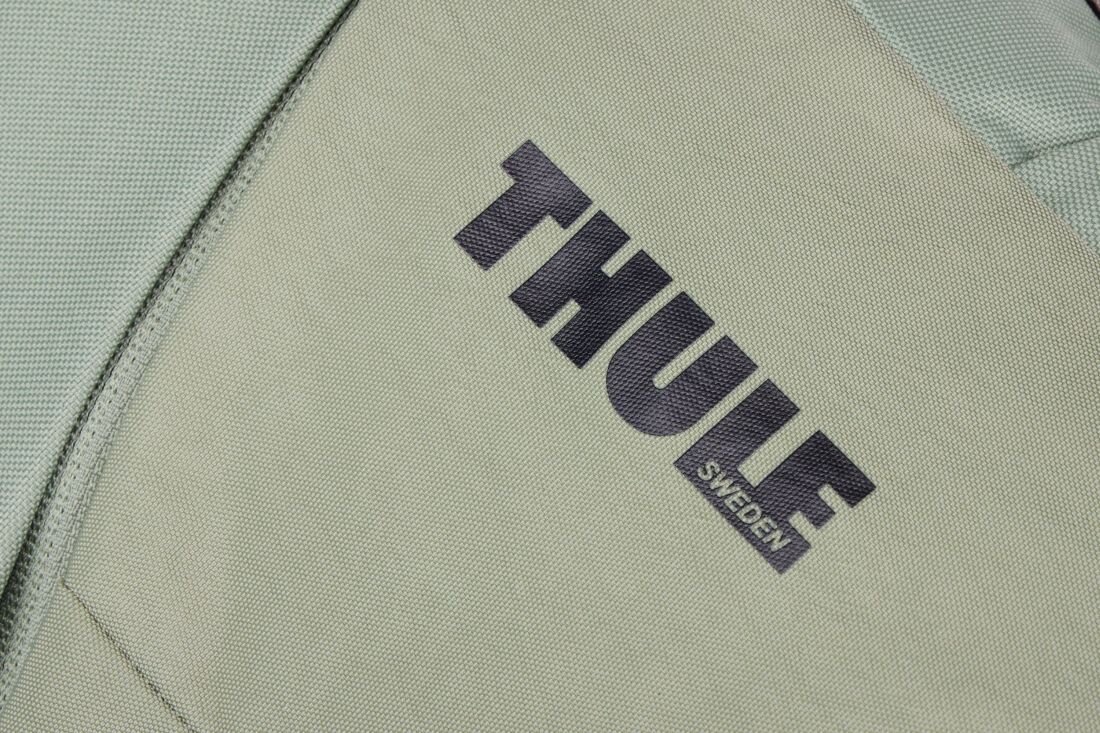 Zbliżenie na jasnozielony materiał z widocznym logo \'THULE SWEDEN\'.