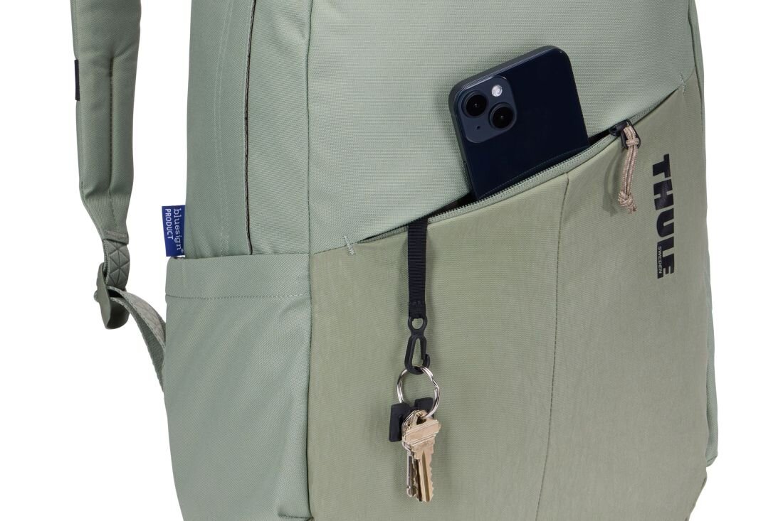 Jasnozielony plecak z kieszenią zewnętrzną, w której znajduje się telefon i klucze. Na plecaku widoczne jest logo \'THULE\'.
