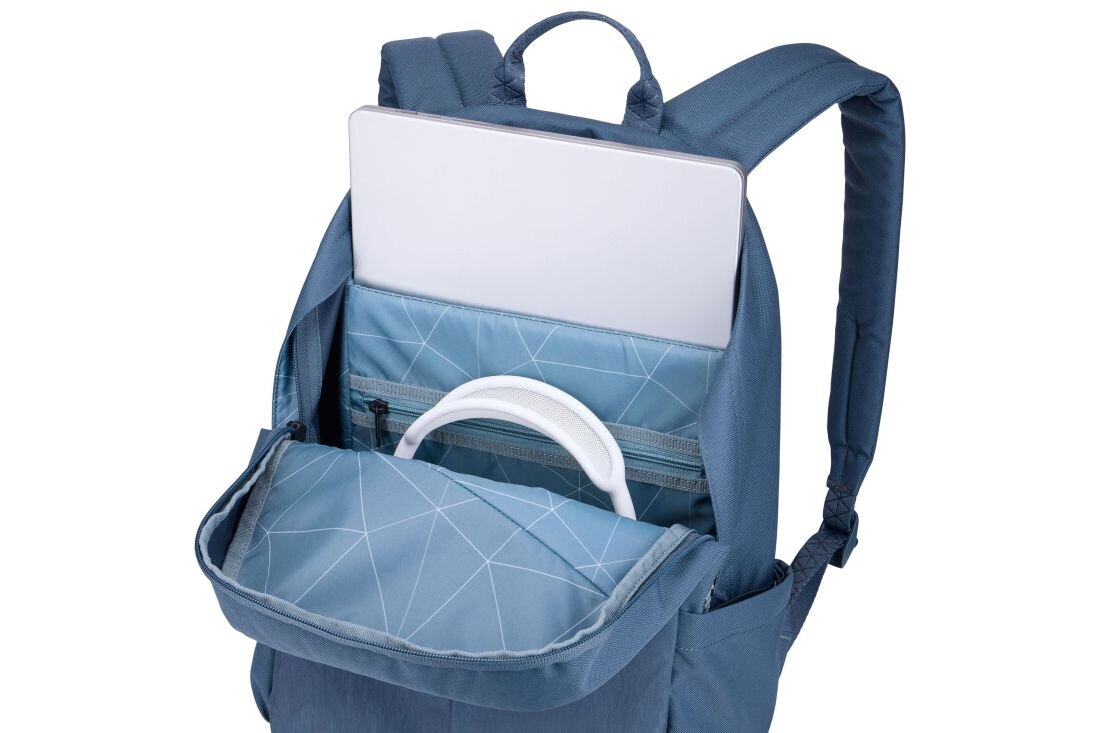 Ciemnoniebieski plecak z otwartą komorą, w której znajduje się laptop oraz słuchawki. Wnętrze plecaka ma geometryczny wzór.