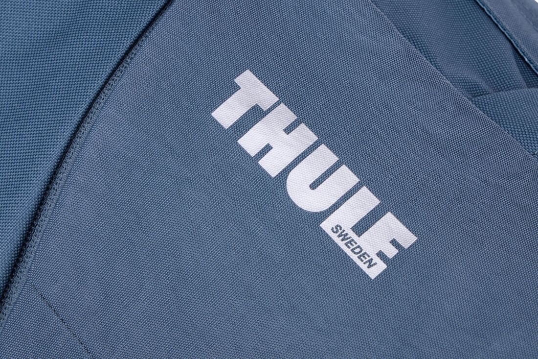 Ciemnoniebieski materiał z widocznym białym logo \'THULE SWEDEN\'.