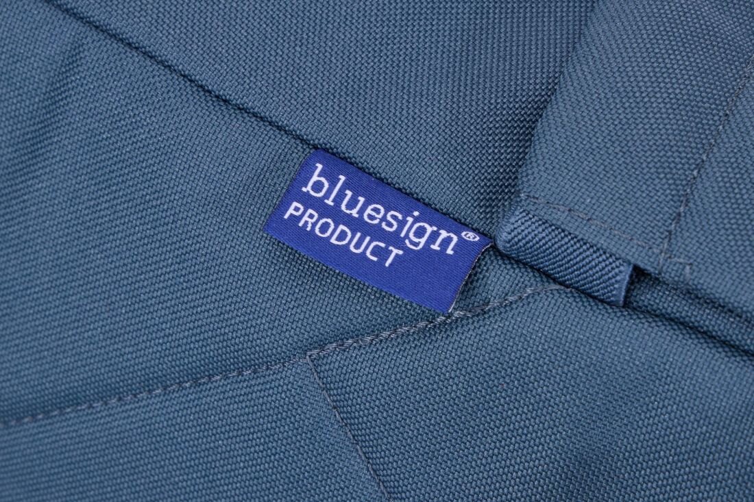 Zbliżenie na ciemnoniebieski materiał z wszywką z napisem \'bluesign PRODUCT\'.