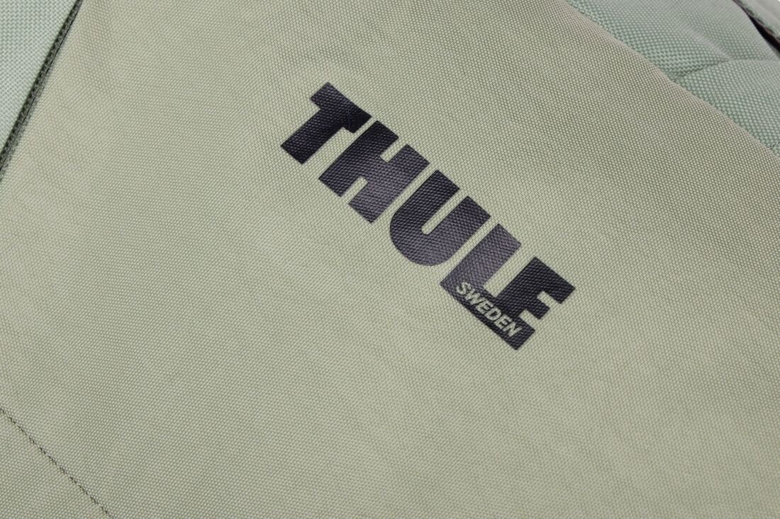 Plecak Thule Gauntlet Sleeve prezentuje logo marki na materiale w zbliżeniu podczas codziennego użytkowania miejskiego 