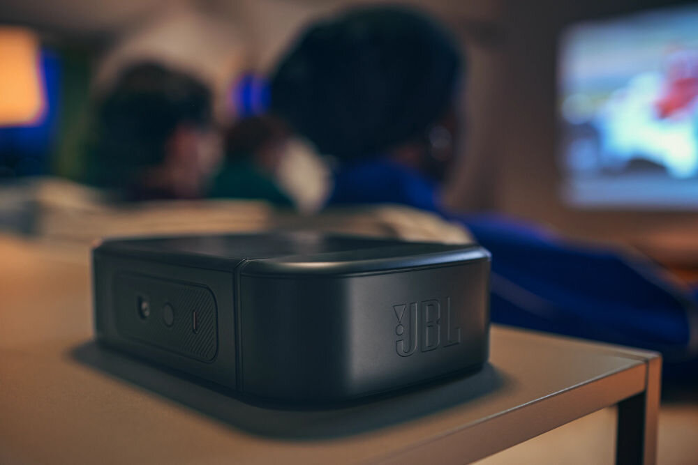 Soundbar JBL BAR 800 MkII 7.1-kanałowy system odłączane głośniki surround subwoofer 10 cali, kadr na odłączony głośnik surround, osoby siedzące na kanapie oglądające film