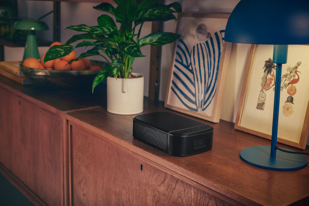 Soundbar JBL BAR 800 MkII odłączane głośniki surround bezprzewodowe akumulator 10h, głośnik surround umiejscowiony na komodzie obok lampki, kwiata oraz obrazów