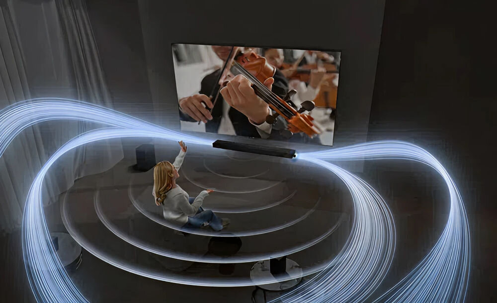 Soundbar TCL Q85H Pro Dolby Atmos DTS:X 7.1.4 potężne brzmienie niskotonowy, osoba siedząca na kanapie zanurzona w dźwikach urzadzenia