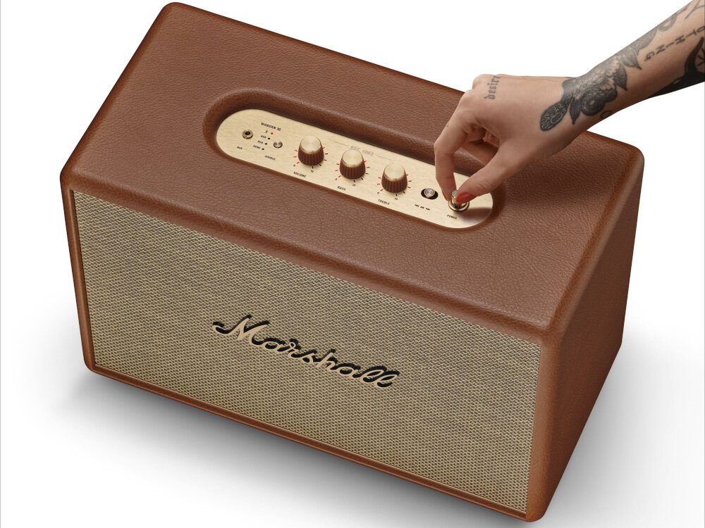 Głośnik mobilny MARSHALL Woburn III - Pełna kontrola, górny panel, pokrętła regulacji głośności, Bluetooth, ręka trzymająca pokrętło głośnika na białym tle