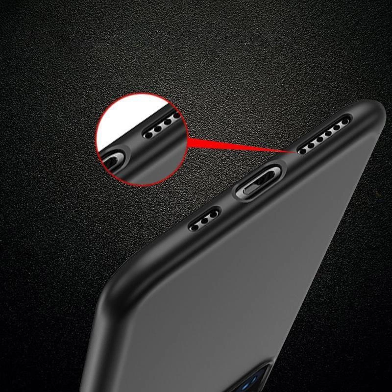 Czarne, elastyczne etui na telefon z wycięciami na porty i głośniki, pokazane na tle ciemnej powierzchni. Zbliżenie na wycięcia podkreślone czerwonym okręgiem.