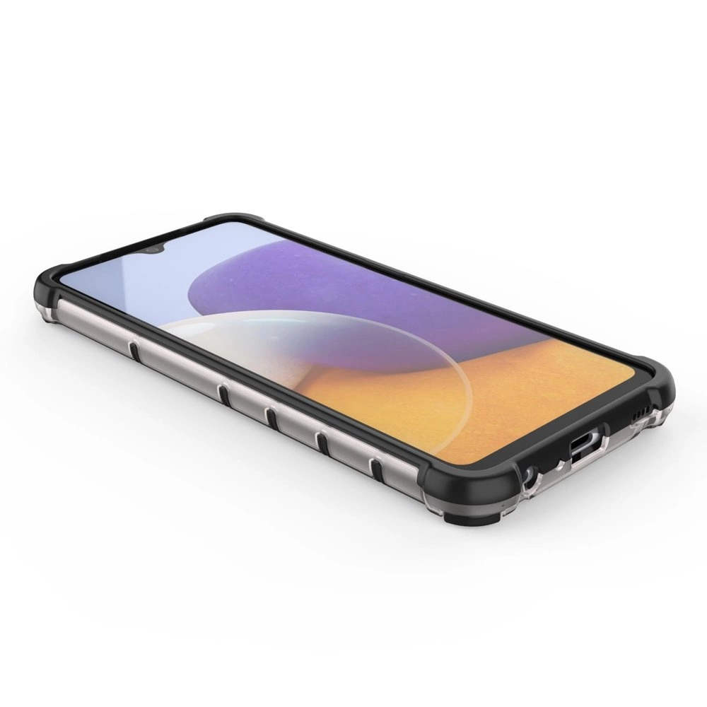 Na obrazie widoczny jest telefon w etui ochronnym z żelową ramką, leżący na białej powierzchni. Etui ma czarne narożniki i przezroczyste boki.