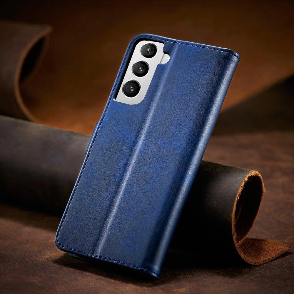 Niebieskie etui z klapką na telefon, z trzema wycięciami na aparaty fotograficzne. Etui leży na brązowym tle z widocznym zwojem materiału.