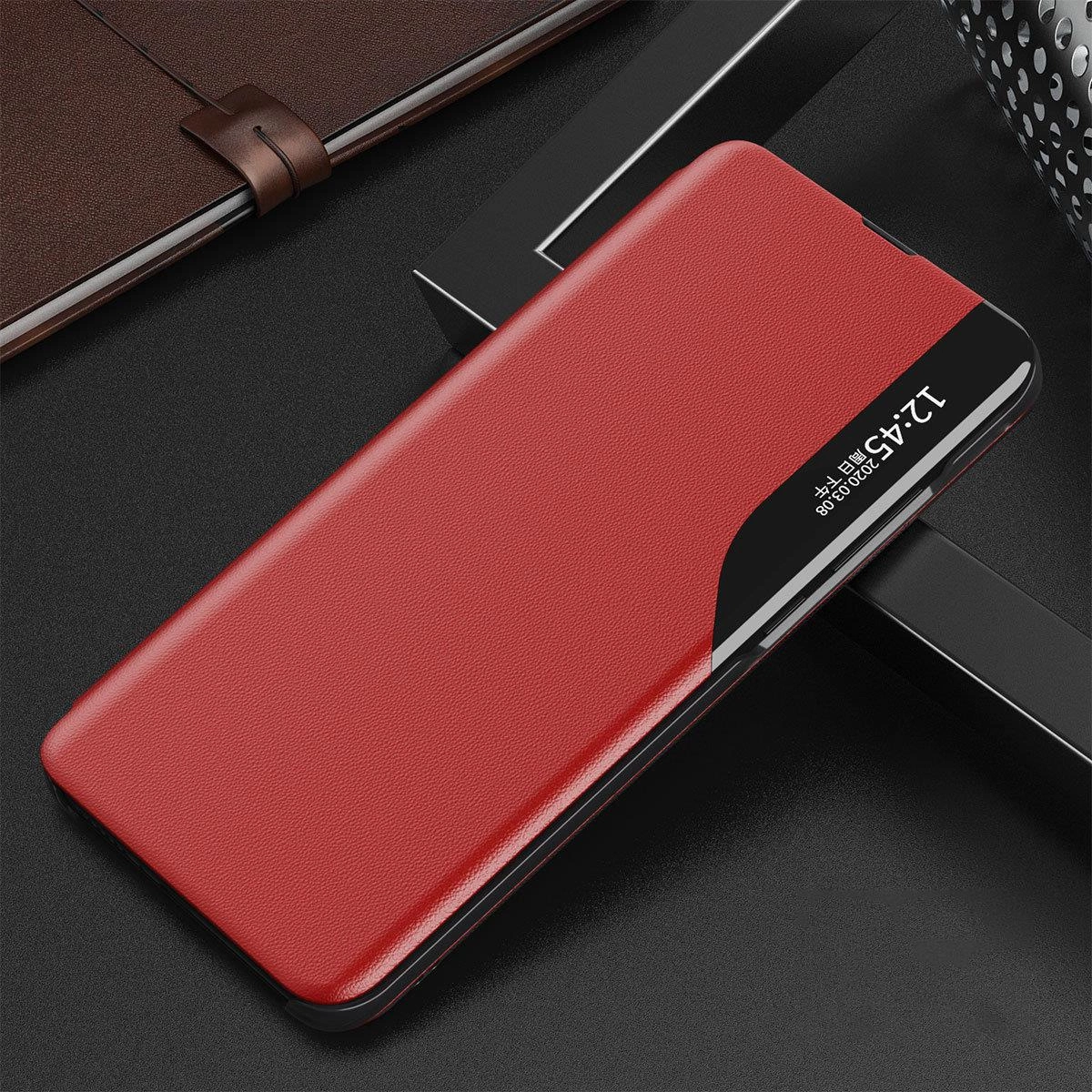 Czerwone etui z klapką na telefon, z funkcją podstawki, leży na ciemnym tle. Na czarnym pasku widoczny jest tekst: \'12:45 2020.08.08\'.