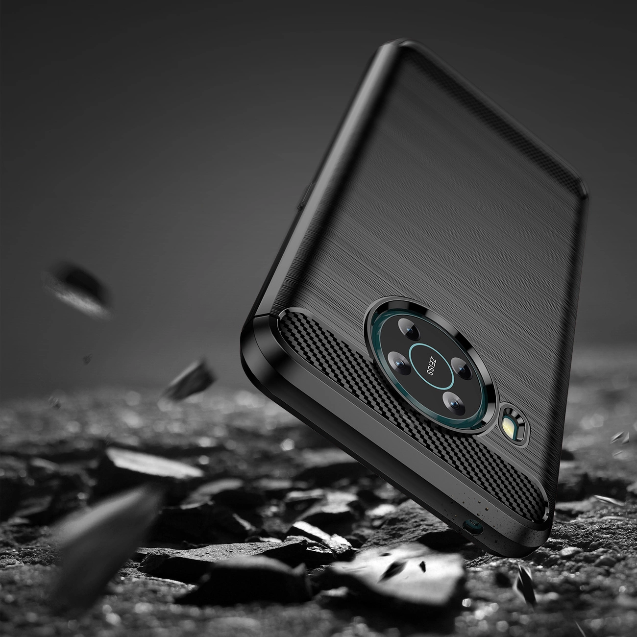 Czarne etui na telefon z teksturą przypominającą włókno węglowe, z wycięciem na aparat fotograficzny. W tle widoczne są unoszące się fragmenty skał.