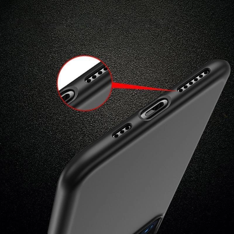 Czarne, elastyczne etui na telefon z wycięciami na porty i głośniki, pokazane na tle ciemnej powierzchni. Zbliżenie na wycięcia podkreślone czerwonym okręgiem.
