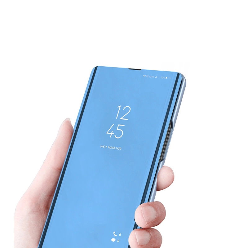Osoba trzyma telefon w czarnym etui z klapką, na ekranie widoczna jest godzina 12:45 oraz data WED, MARCH 29. W dolnej części ekranu znajdują się ikony telefonu i wiadomości z liczbami 6 i 8.