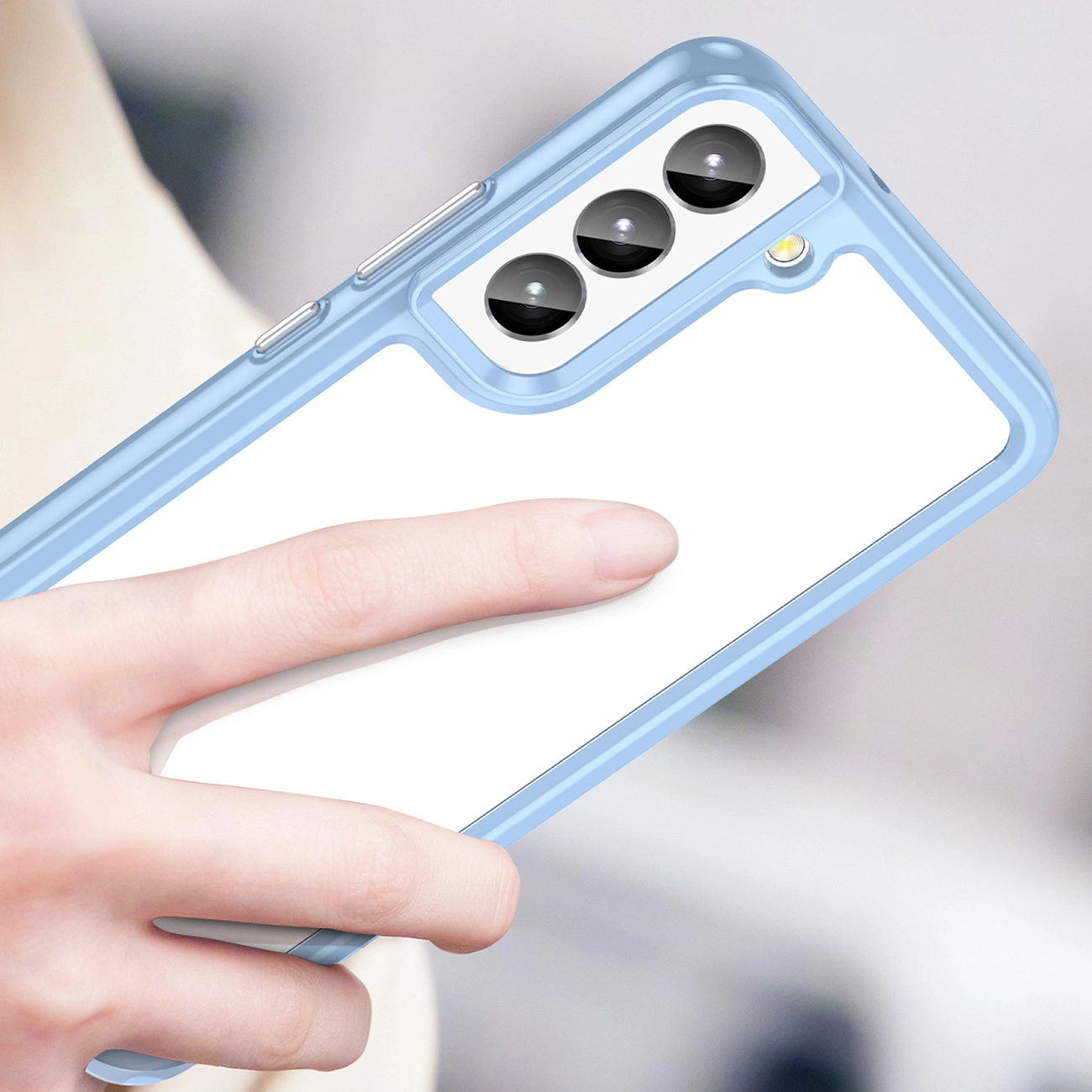 Osoba trzyma telefon w niebieskim etui z trzema widocznymi obiektywami aparatu i lampą błyskową.