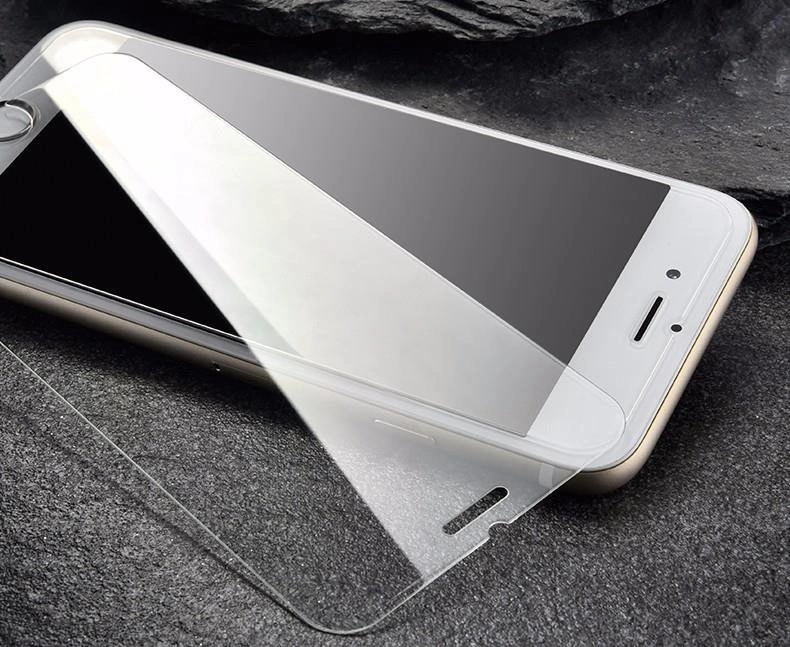 Na obrazie widoczny jest smartfon z nałożonym szkłem hartowanym, leżący na ciemnej powierzchni. Szkło jest przezroczyste i dopasowane do ekranu urządzenia.