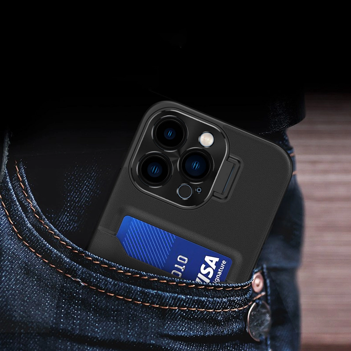 Czarny pokrowiec na telefon z trzema obiektywami aparatu i miejscem na kartę, widoczny w kieszeni jeansów. W pokrowcu znajduje się niebieska karta z napisem \'VISA Signature\'.