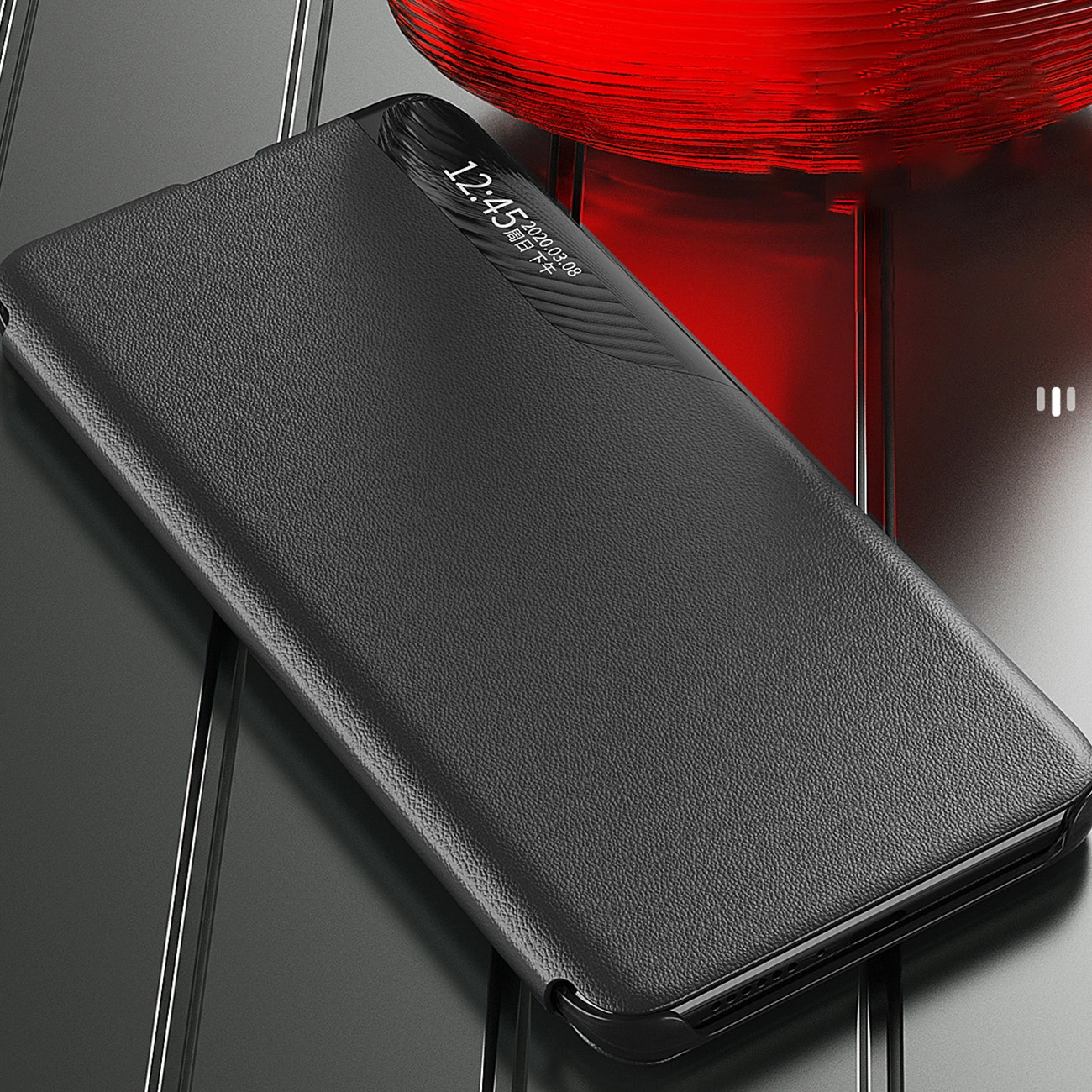 Czarne etui z klapką na telefon, wykonane z materiału imitującego skórę, leży na metalicznej powierzchni. Na etui widoczny jest wyświetlacz z godziną 12:45 i datą 2023.08.38.