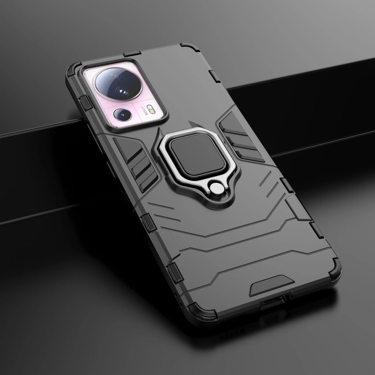 Czarne etui ochronne z magnetycznym uchwytem na telefon, z widocznymi wycięciami na aparat. Etui ma pancerne wzory i metaliczny element w centralnej części.