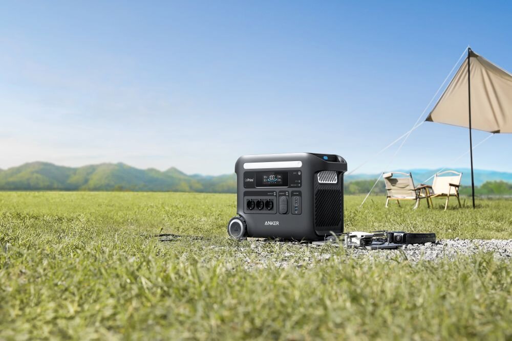 Stacja zasilania ANKER Solix F2600 2560 Wh 2300W, bateria, rozszerzającej, pojemność, zwiększyć, stacja zasilania stoi na trawniku w tle górzysty teren