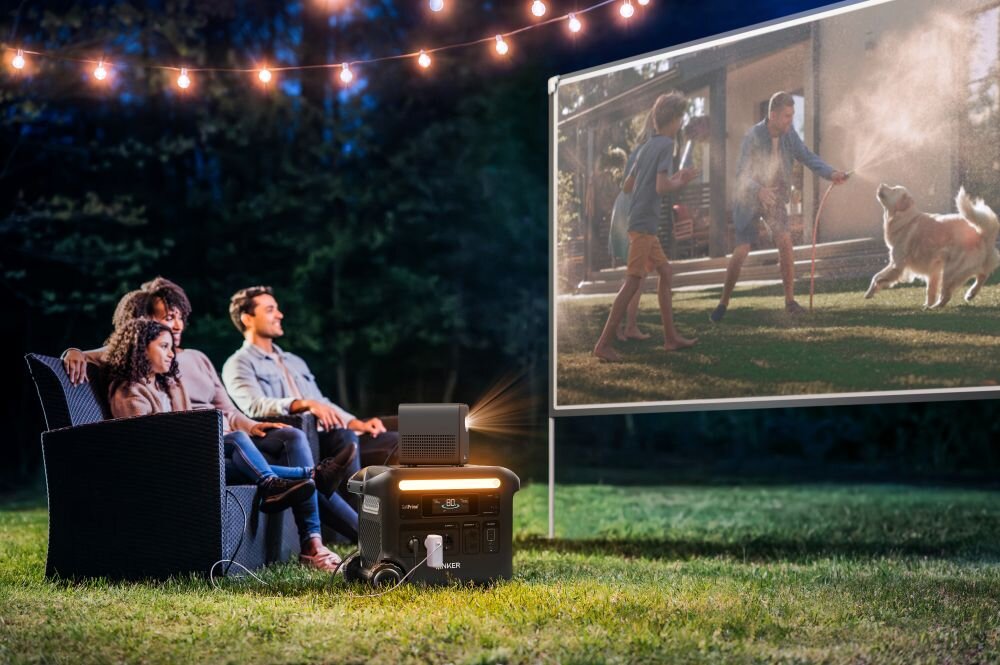 Stacja zasilania ANKER Solix F2600 2560 Wh 2300W, UPS, ms, krytyczne, bez przerwy, rodzina ogląda w ogródku film na rzutniku podłączonym do stacji zasilania