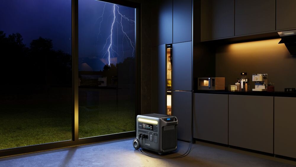 Stacja zasilania ANKER Solix F2600 2560 Wh 2300W, zasilanie, spokój, nieplanowe, pojemnośc, moc, stacja stoi w kuchni podłączona do sprzętu AGD, w tle burzowa pogoda