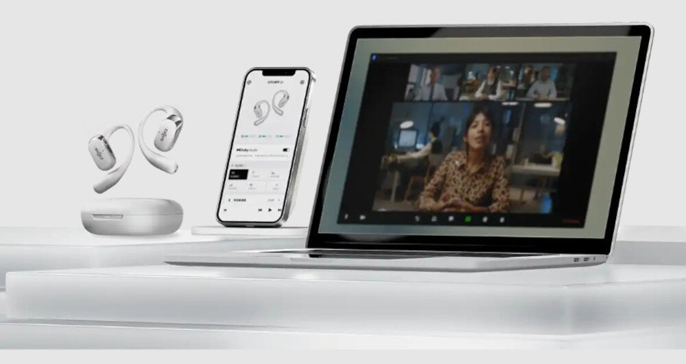 Słuchawki SHOKZ OpenFit 2+ Bluetooth 5.4 multipoint 48 godzin, słuchawki, smartfon oraz laptop na białym blacie