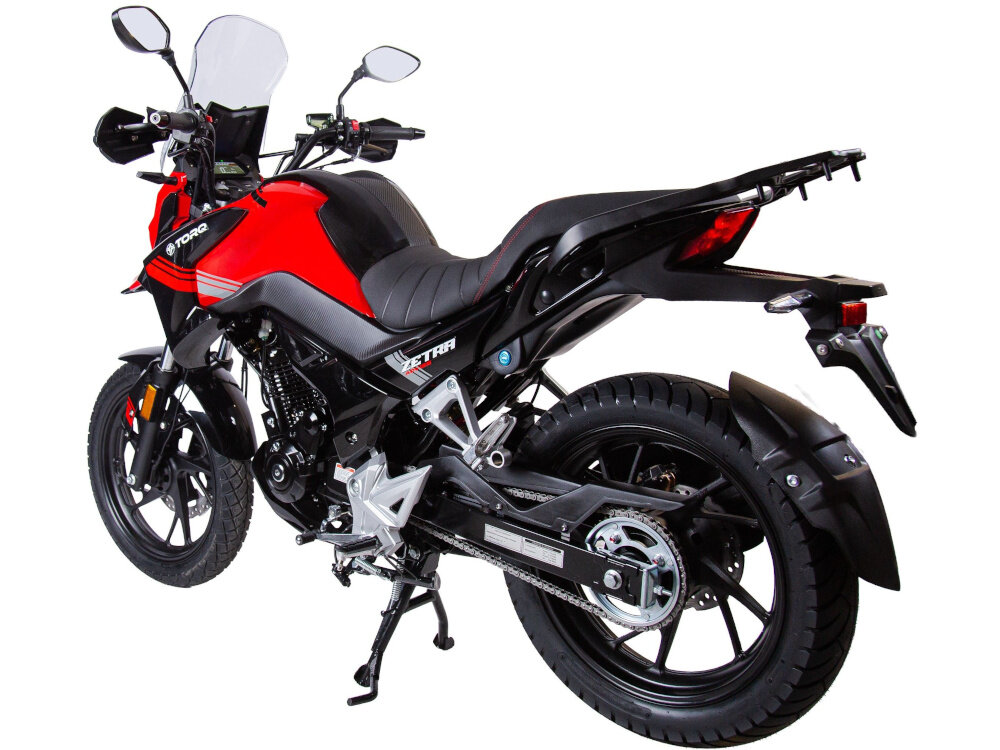 Motocykl TORQ Zetra ADV 125 MC125-5 124.4cm3 11l Czarno-czerwony motocykl na białym tle widoczny od tyłu pod skosem łańcuchowe przeniesienie napędu ułatwia codzienną eksploatację zmniejsza koszty serwisowania regularne smarowanie łańcucha jest szybkie i wygodne trwała konstrukcja przekłada się na stabilną pracę
