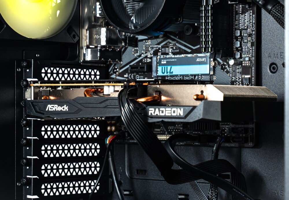 Komputer OPTIMUS E-Sport GA520T-CR9 Wnętrze jednostki centralnej widoczne przez boczną szybę obudowy. Widoczny jest tylny wentylator z żółtym podświetleniem, okrągłe chłodzenie procesora oraz karta graficzna z napisem 'GEFORCE RTX', karta graficzna, wydajność
