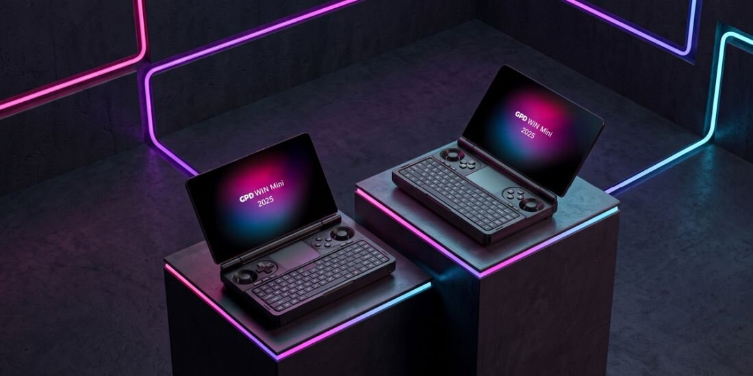 Dwa laptopy z otwartymi ekranami, na których widnieje napis \'GPD Win Mini 2023\', stoją na podestach w otoczeniu neonowych świateł. Każdy laptop ma klawiaturę i kontrolery do gier po bokach.